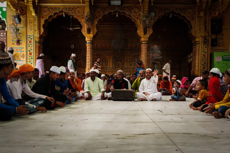 Qawalli at Ajmer Sharif Dargah, religious expressionism, a group performance, Sufi origin, “shehen-shah-e-qawwali”, Nusrat Fateh Ali Khan, Waris Brothers, Rizwan Muazzam, Faiz Ali Faiz and Waheed and Naveed Chistis